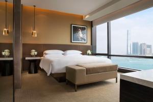 香港香港君悦酒店的一间卧室设有一张大床和一个大窗户