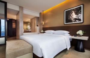 香港香港君悦酒店的卧室配有一张白色的大床和一张桌子