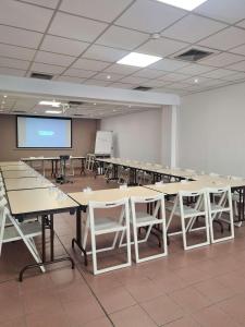 土伦Ibis Budget Toulon Centre的大房间设有桌椅和投影屏幕