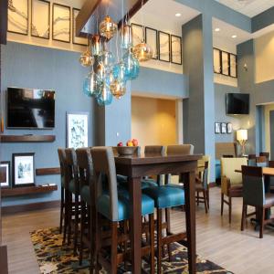 斯特劳兹堡Hampton Inn & Suites Stroudsburg Bartonsville Poconos的用餐室以及带桌椅的起居室。