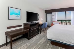 沃尔顿堡滩沃尔顿堡滩汉普顿酒店的酒店客房配有一张床和一张书桌及一台电视