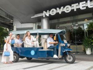 曼谷Novotel Bangkok Platinum Pratunam的一群人乘坐高尔夫球车