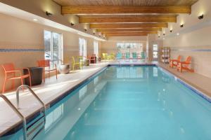 史密斯堡史密斯堡希尔顿欣庭套房酒店的一座带橙色椅子和桌子的酒店游泳池