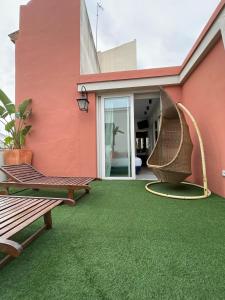 塞维利亚塞维利亚市中心公寓式酒店的庭院设有绿意盎然的草坪和长凳