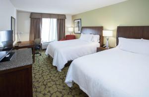 弗洛伍德杰克逊/弗洛伍德希尔顿花园酒店的酒店客房设有两张床和电视。