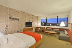 欧克莱尔利斯莫尔酒店欧克莱尔 - 希尔顿逸林酒店的酒店客房配有床、沙发和电视。