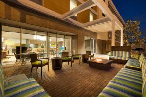 休斯顿Home2 Suites by Hilton Houston Energy Corridor的一个带桌椅的庭院和一间客厅