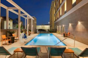 休斯顿Home2 Suites by Hilton Houston Energy Corridor的一个带椅子的游泳池和一间酒店