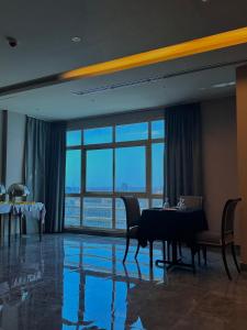 麦纳麦MIRADOR HOTEL的一间带桌椅和窗户的用餐室