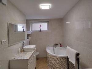 卢布林Piasecki Apartamenty的带浴缸、水槽和浴缸的浴室