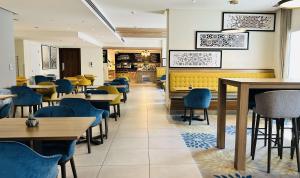 迪拜Hampton By Hilton Dubai Al Barsha的一间配备有桌子和蓝色椅子的用餐室
