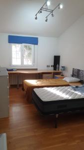 莫斯托雷斯Casa Pinares的一间卧室设有两张床、一张桌子和一个窗口。