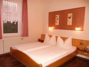 奥伯霍夫Pension Haus Flora的一间卧室配有一张带白色床单的床和一扇窗户。