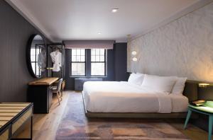纽约The Time New York, part of JdV by Hyatt的一间卧室配有一张床、一张书桌和一面镜子