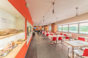 里昂Residence Montempo Lyon Cite Internationale的用餐室配有桌子和红色椅子