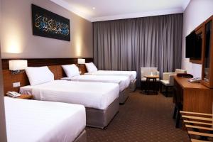麦加فنادق رزون المسك مكة المكرمة的酒店客房设有三张床和电视。