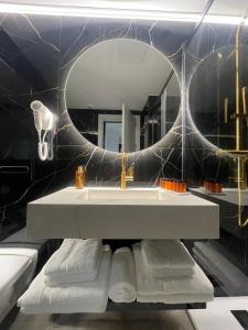 塞维利亚塞维利亚市中心公寓式酒店的一间带水槽和镜子的浴室