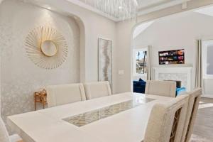 圣地亚哥Champagne Taste Luxury Home in Hillcrest的白色的用餐室配有白色的桌椅