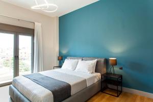 海若克利欧Minimal Loft Art with Sea View Over Heraklion Harbour的一间卧室设有一张蓝色墙壁的大床