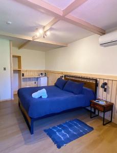 圣何塞德迈波La Petite France的一间卧室配有一张蓝色的大床和一张桌子