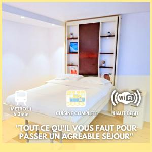 圣芒代La Perle Blanche- Studio Chic- Metro L1 Saint-Mandé的一间卧室设有一张床和一个书架