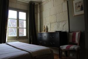 圣艾尼昂拉提拉希德塔芙度假屋的一间卧室配有一张床、一个梳妆台和一扇窗户。