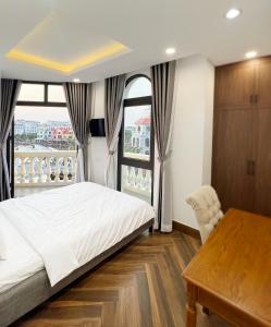 富国Legacy Phú Quốc的卧室配有一张床、一张书桌和窗户。