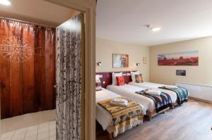 布吕隆Hotel Le Ranch的一间卧室设有两张床和滑动玻璃门