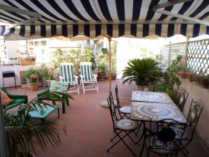 夏卡Casa vacanze Sciacca的一个带桌椅和条纹雨伞的庭院