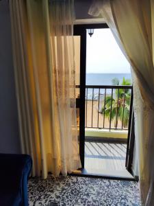 克里比HOTEL DE L'OCEAN KRIBI的一间设有一扇门的客房,可通往一个海景阳台