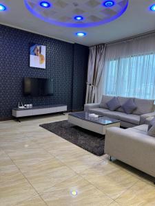 麦纳麦Amfas Suites اجنحة امفاس的带沙发和电视的客厅