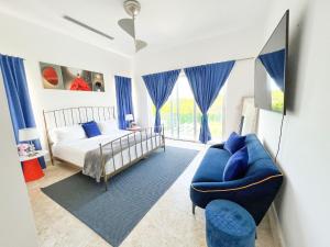 蓬塔卡纳Kosher casa的一间卧室配有一张床和一张蓝色的沙发