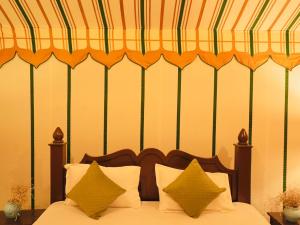 山姆Venture Desert Camp Jaisalmer的一间卧室配有带条纹天蓬的床
