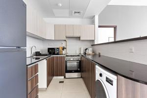 阿布扎比Silkhaus Modern 1BDR in Najmat Near Reem Central Park的厨房配有白色橱柜和炉灶烤箱。