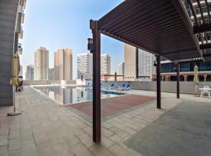 阿布扎比Silkhaus Modern 1BDR in Najmat Near Reem Central Park的楼房屋顶上的亭子,带有游泳池