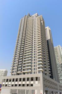 阿布扎比Silkhaus Chic 1BDR at Najmat Near Reem Central Park的一座高大的建筑,城市里有很多窗户