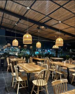 佩雷拉兹万豪华酒店的餐厅设有木桌、椅子和吊灯。