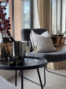 洛姆BrimiBue Hotel的椅子旁边的桌子上放两杯葡萄酒