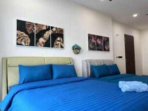 马西Cozy couple apartment suite的卧室内的两张床,配有蓝色床单和墙上的照片