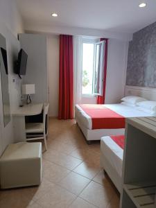 瓦拉泽丽多酒店的酒店客房设有两张床、一张书桌和一个窗户。