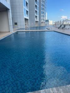 阿吉曼Ocean View Luxury Suites的大楼里的一个大型蓝色游泳池