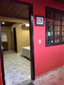阿拉夏奇巴海滩Pousada Convés - Ilha Grande的一道红色的门通向一间设有床铺的房间