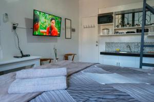 桑托斯将军城Apartment near Malls的卧室配有一张床,墙上配有电视。