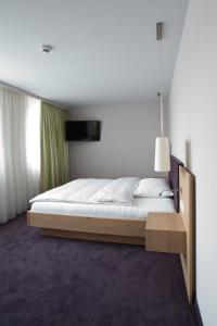 伦茨堡OCHSEN LODGE by Ochsen Lenzburg的一间卧室配有一张木架大床