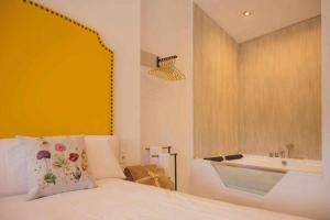 阿尔卡拉德尔胡卡尔LOFT TÚ y YO的一间卧室设有一张床、一个窗口和一个浴缸
