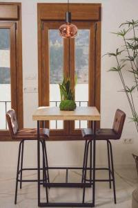 阿尔卡拉德尔胡卡尔LOFT TÚ y YO的一张桌子,上面有两把椅子和盆栽植物