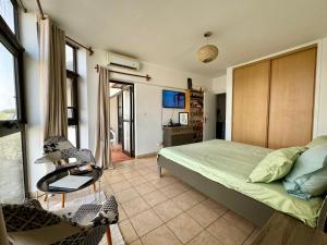 达喀尔Mansa home的卧室配有一张床和一张桌子及椅子