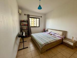 达喀尔Mansa home的一间卧室设有一张床和一个书架