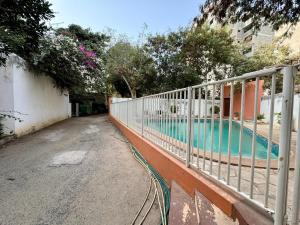 达喀尔Mansa home的建筑物旁游泳池旁的围栏