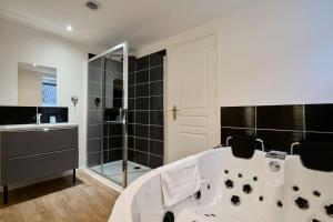 图尔昆NG SuiteHome - Lille l Tourcoing l Haute - Duplex 4 pers - Balnéo - Netflix - Wifi的设有带浴缸和淋浴的浴室。